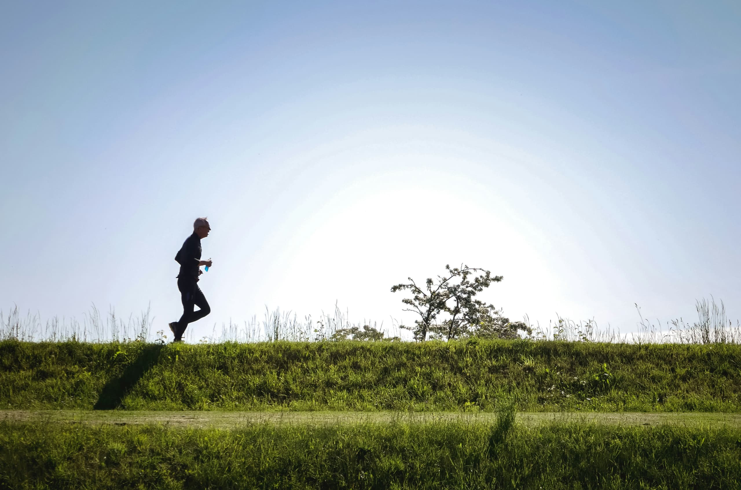 A man in silhouette runs across the horizon