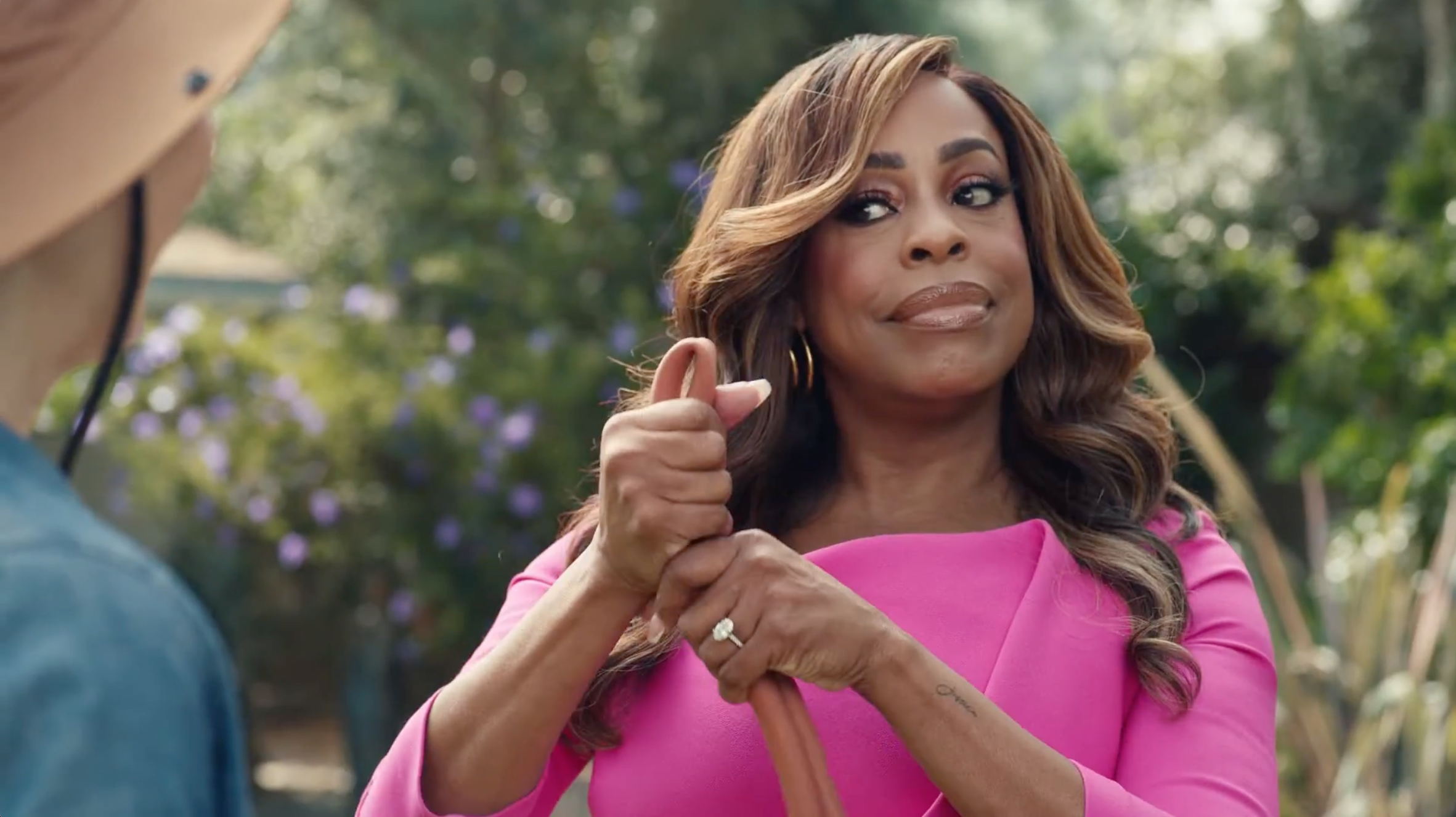 Niecy Nash holds a hose in a bind with a knowing look on her face