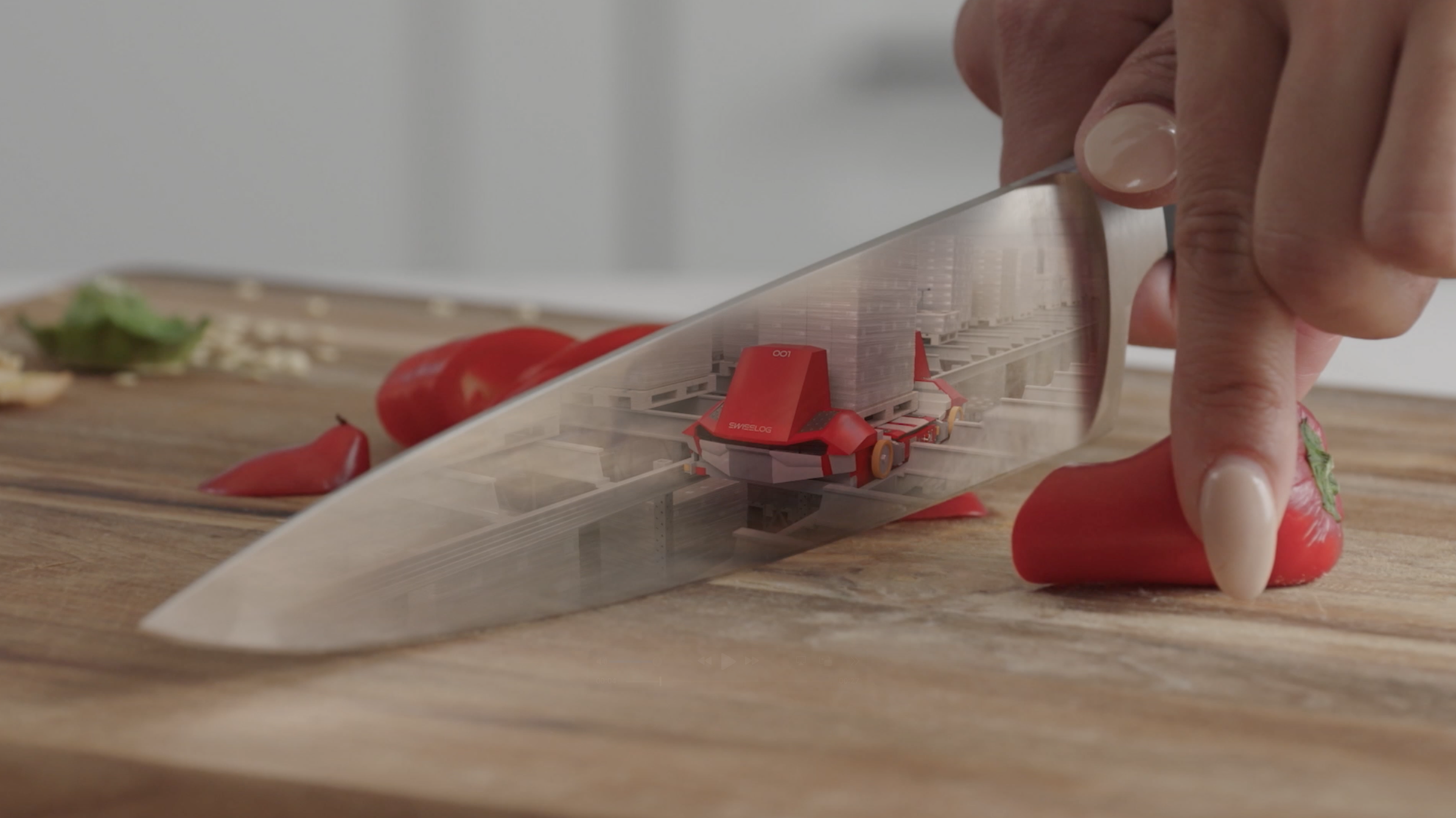 Close up of a knife slicing through a pepper, the reflection on the knife shows the inner workings of a factory