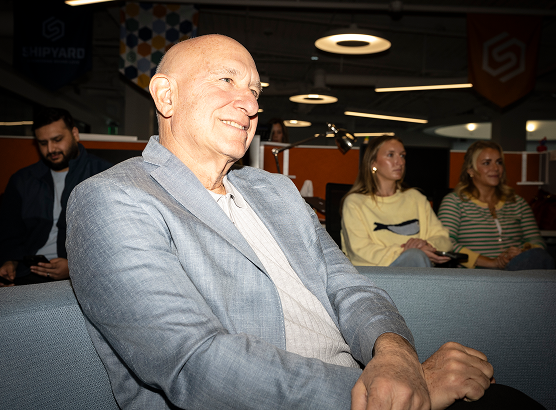 Rick Milenthal in a sport coat, seated on a couch, smiling
